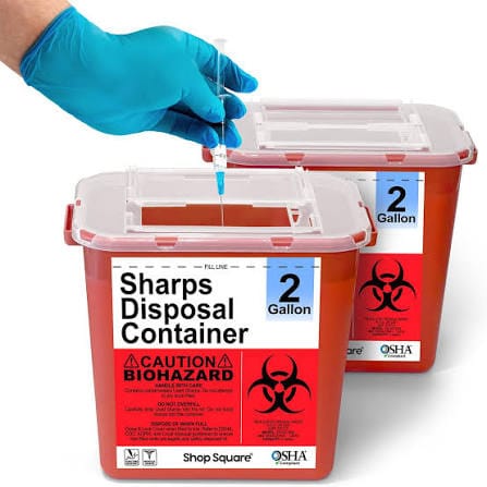 Proper disposal of a needle and syringe in a biohazard bin