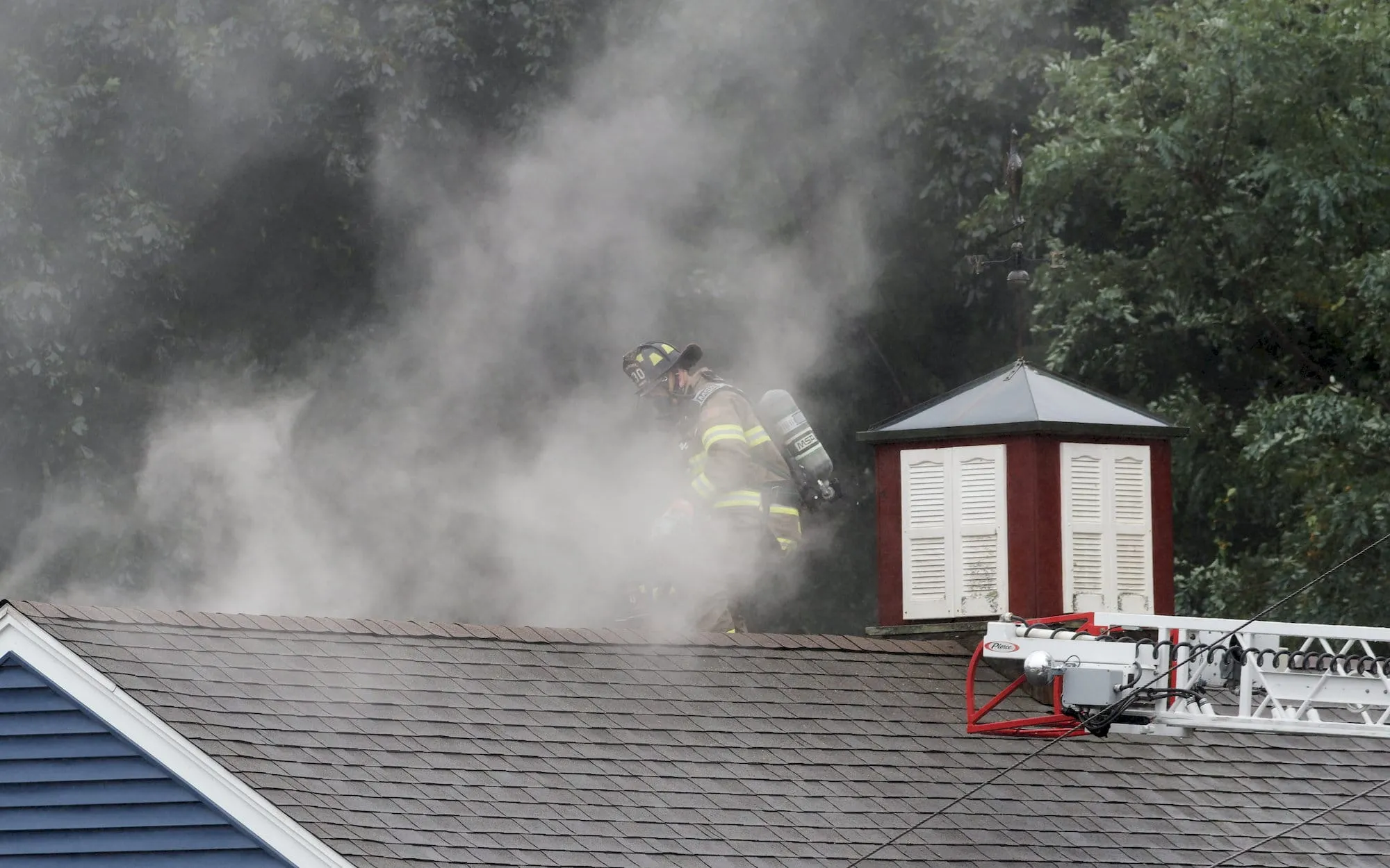 A firefighter working on the roof of the Callahan Auto Supply store. Photo by Will Tavares