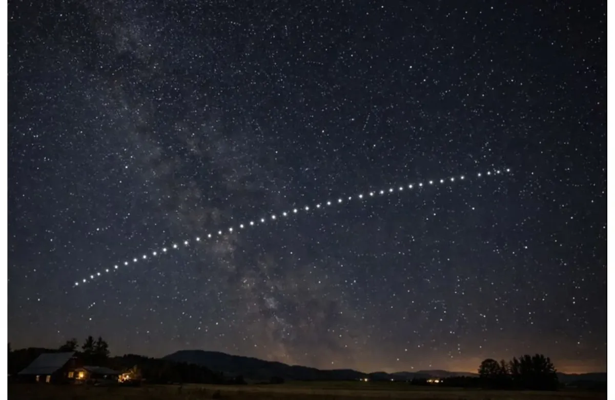 Starlink satellites appearing in a straight line across the night sky above a rural area.