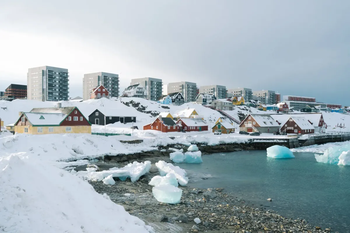 Arctic city in winter with snow-covered buildings and reduced lighting, showing how power outages affect daily life in extreme cold.