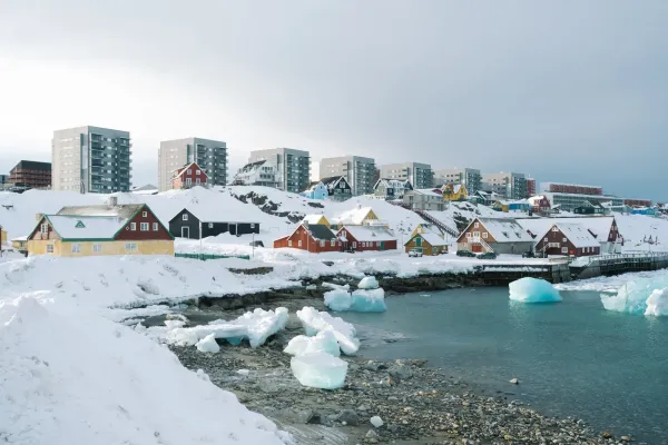 Arctic city in winter with snow-covered buildings and reduced lighting, showing how power outages affect daily life in extreme cold.