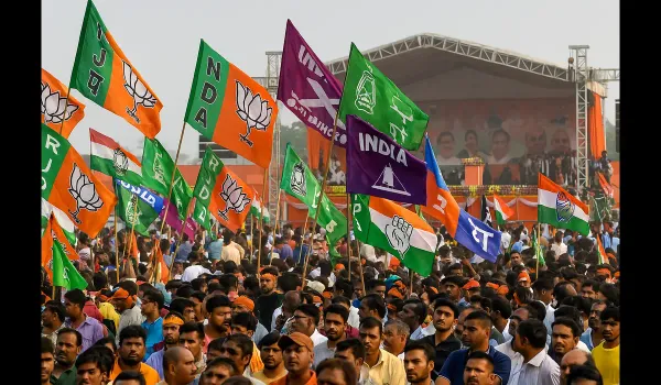 Supporters gather at a Bihar election rally featuring NDA and Grand Alliance flags.