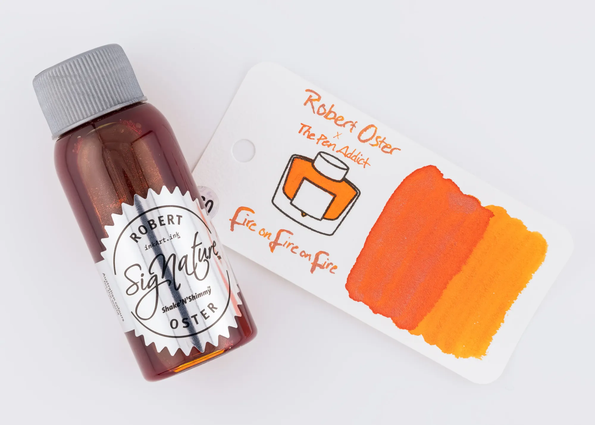 Overhead photo of a Robert Oster ink bottle next to a swatch of the orange shimmer ink on a white background.