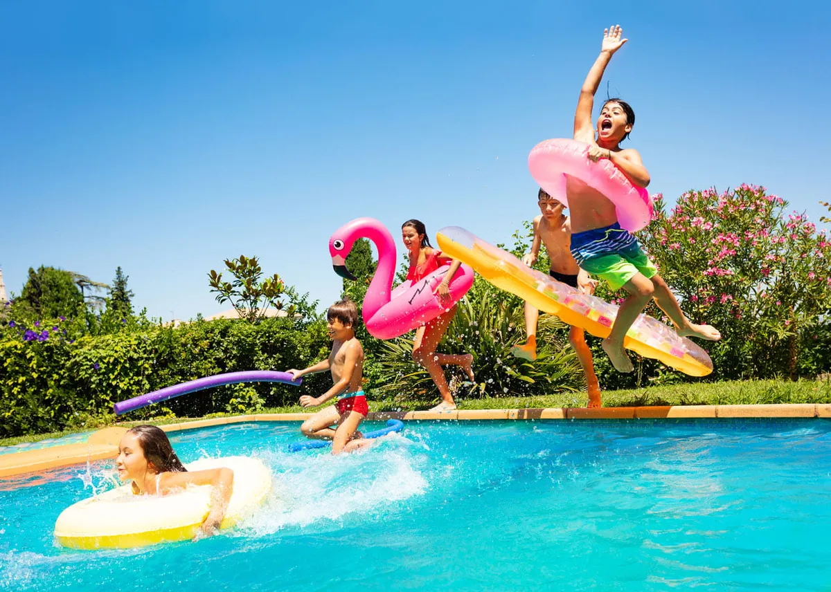 Amis heureux de sauter dans la piscine sur les vacances