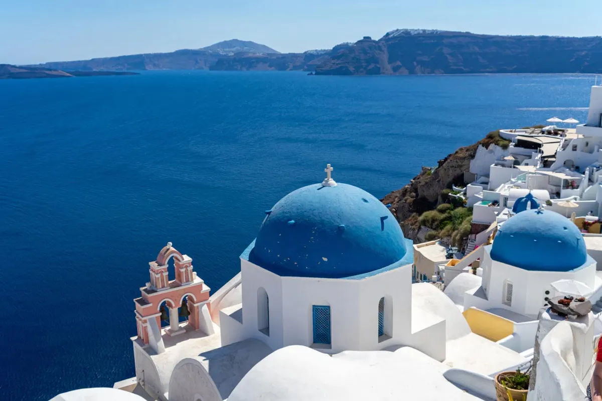 Église en dôme bleu le long du bord de caldeira à Oia, Santorin en Grece