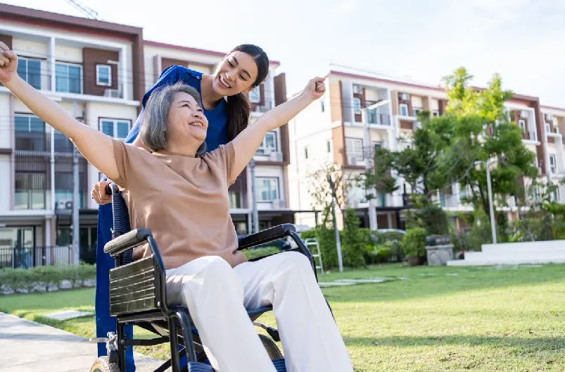 Femme En Fauteuil Assistée D'une Infirmière