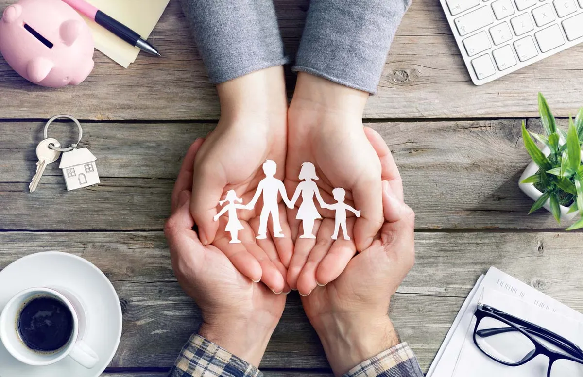 concept de mise à l'abris de la famille avec une assurance. Famille en papier dans 4 mains jointes