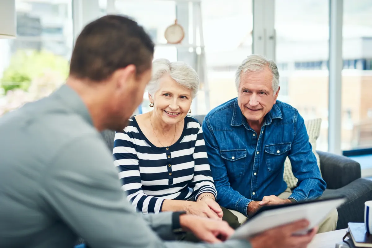 Un conseiller explique à deux seniors les détails de leur assurance retraite