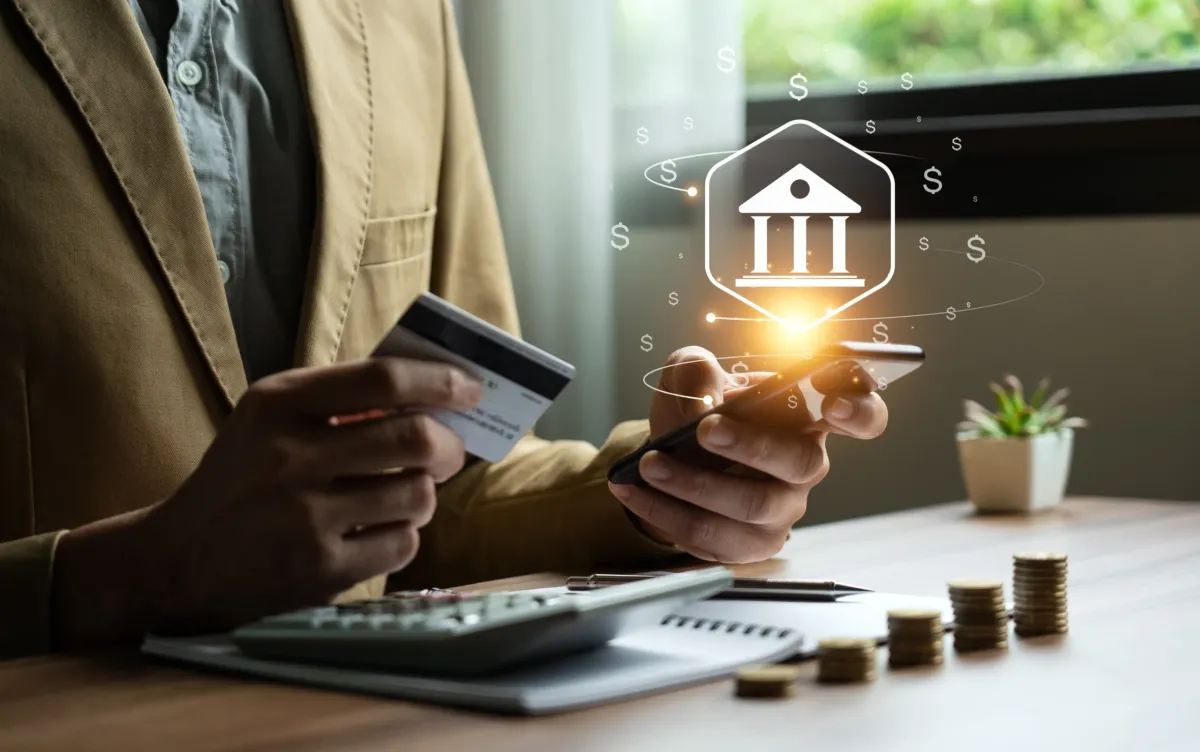 Homme tenant un carte bancaire entre ses mains et faisant des transactions en ligne