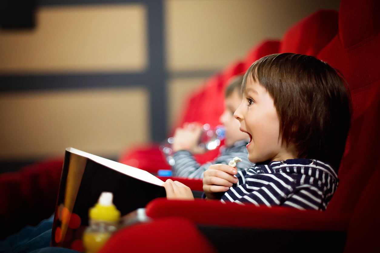 deux frères regarde le film au cinéma et mangent des pop corn 
