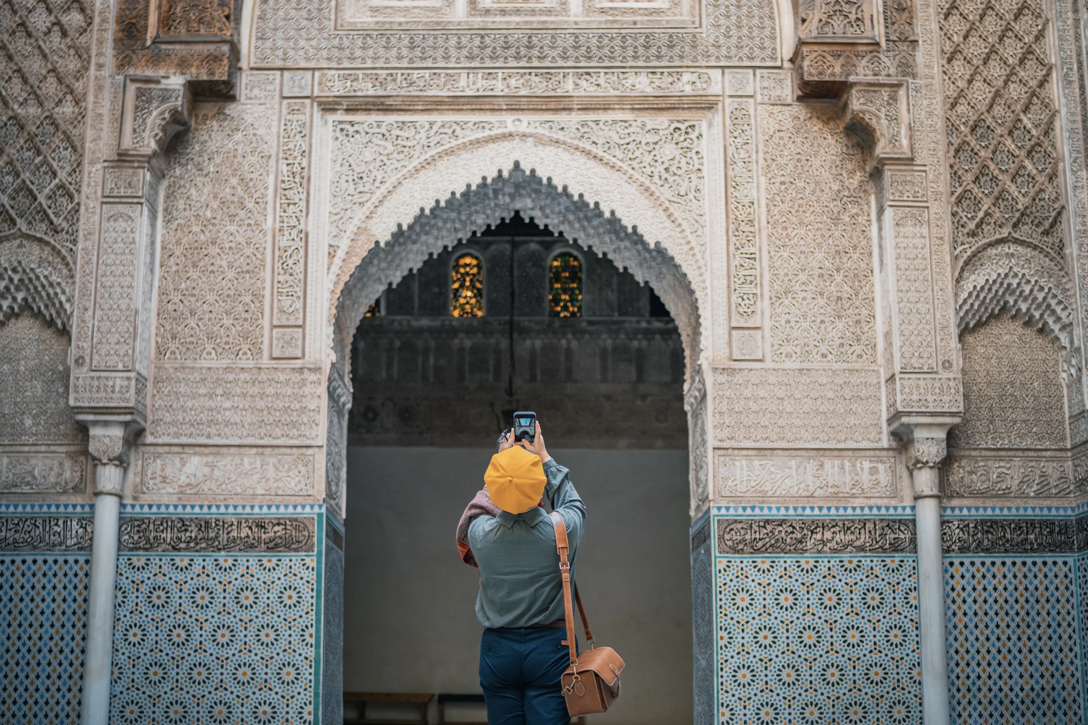 Une touriste chinoise d’origine asiatique photographie et admire la mosquée de Fès Bou Inania Madressa