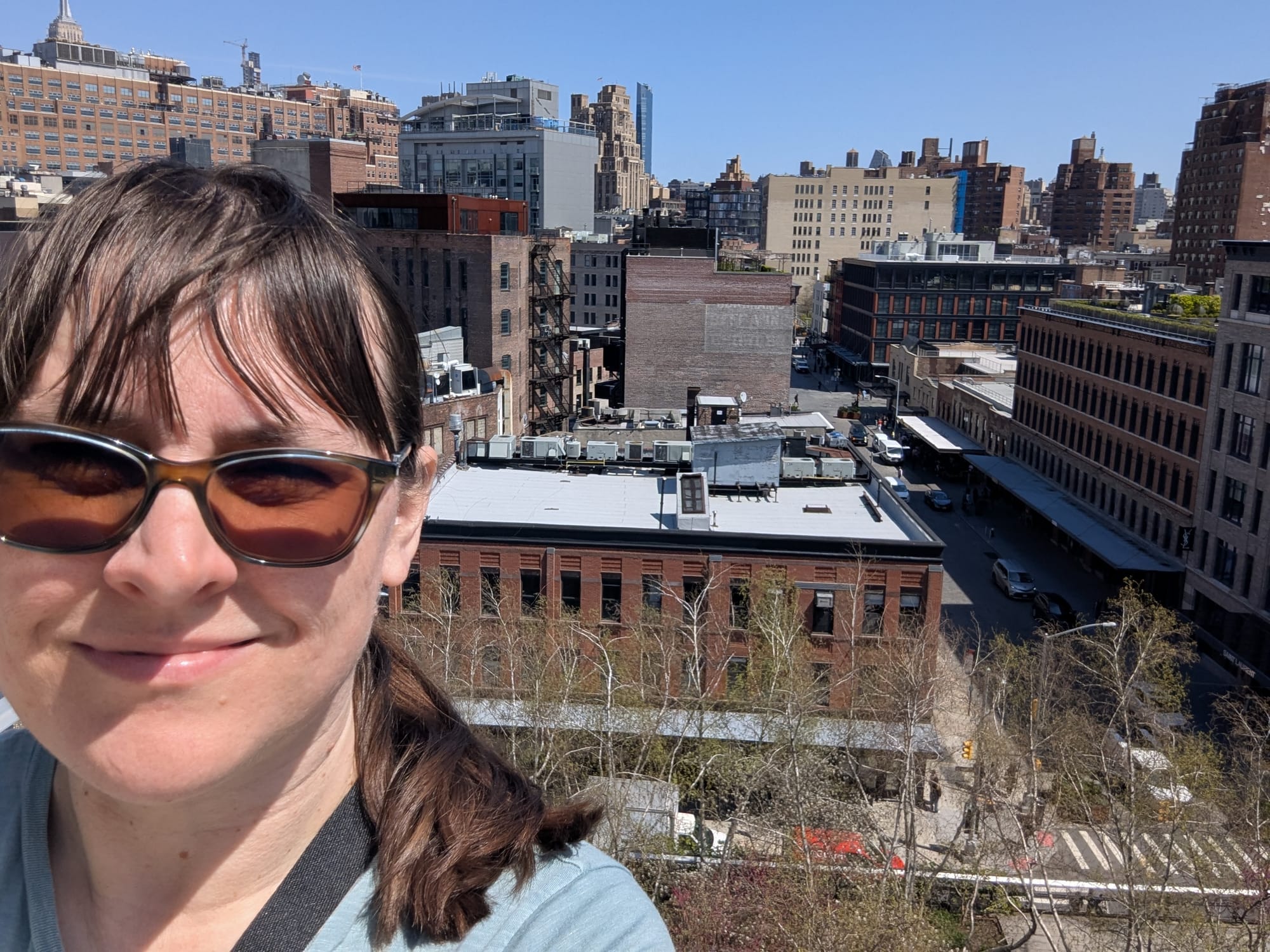 A selfie of the author on the balcony of a building in Chelsea, Manhattan, with a cityscape in the background