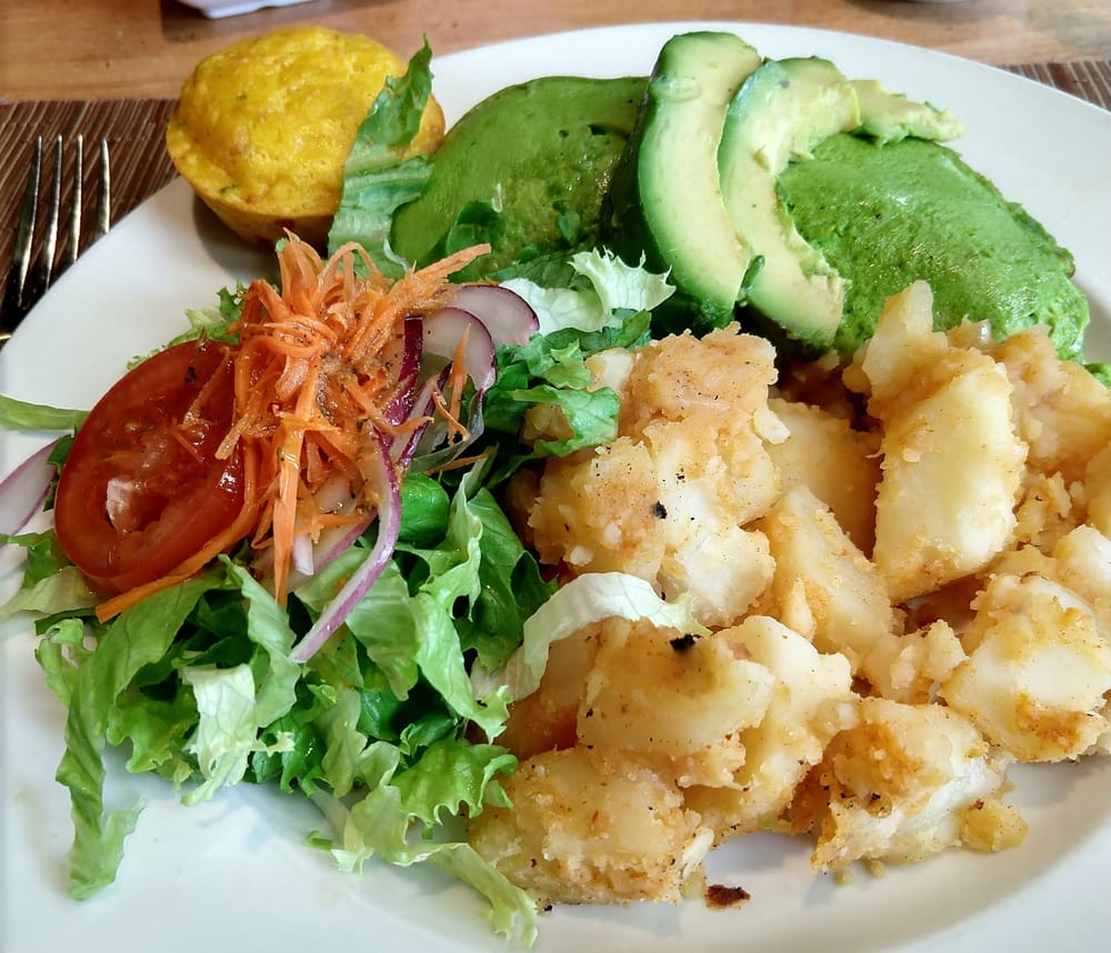A plate of omelet, potatoes, salad, and cornbread