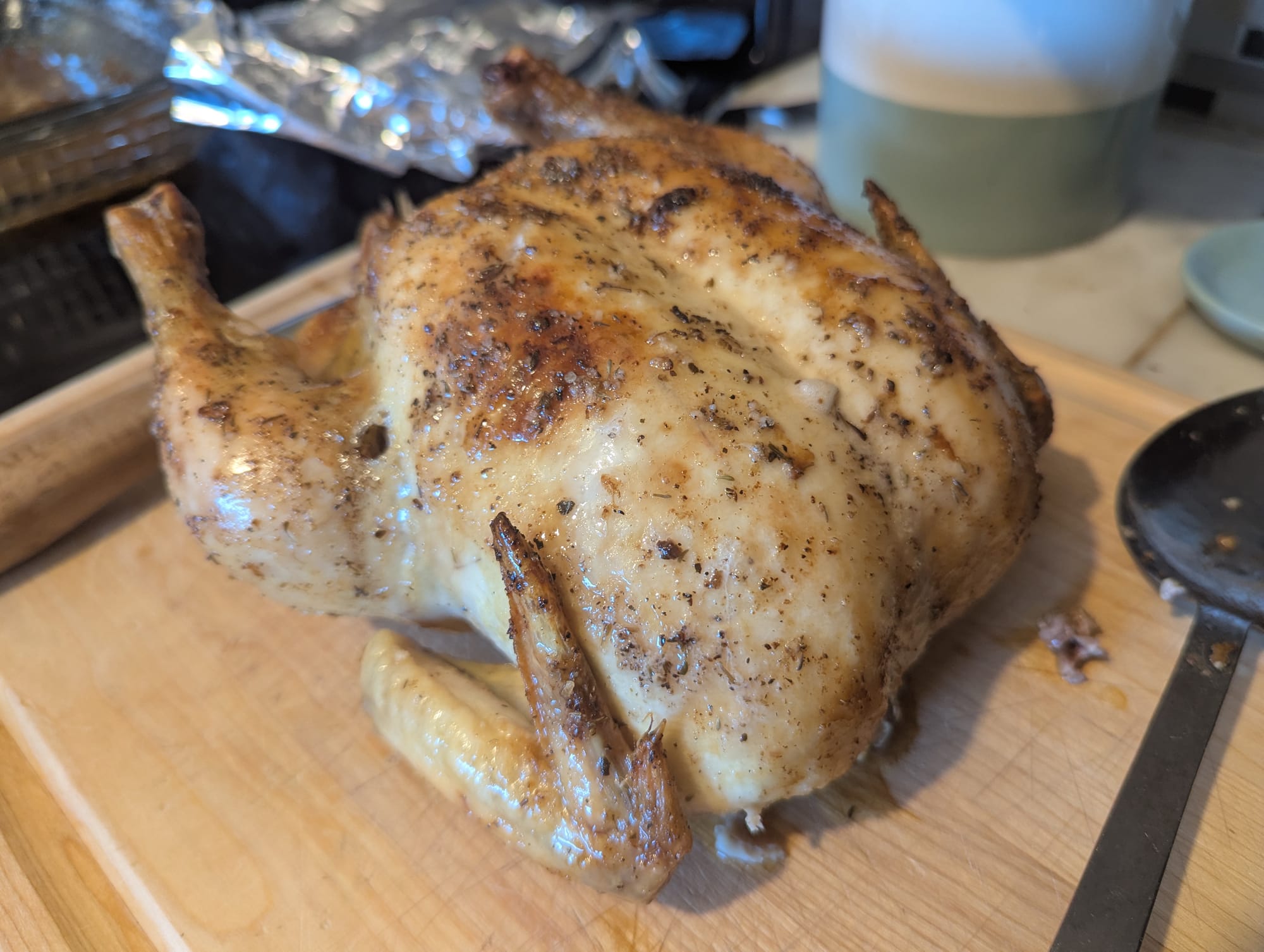 A freshly roasted chicken sits on a cutting board