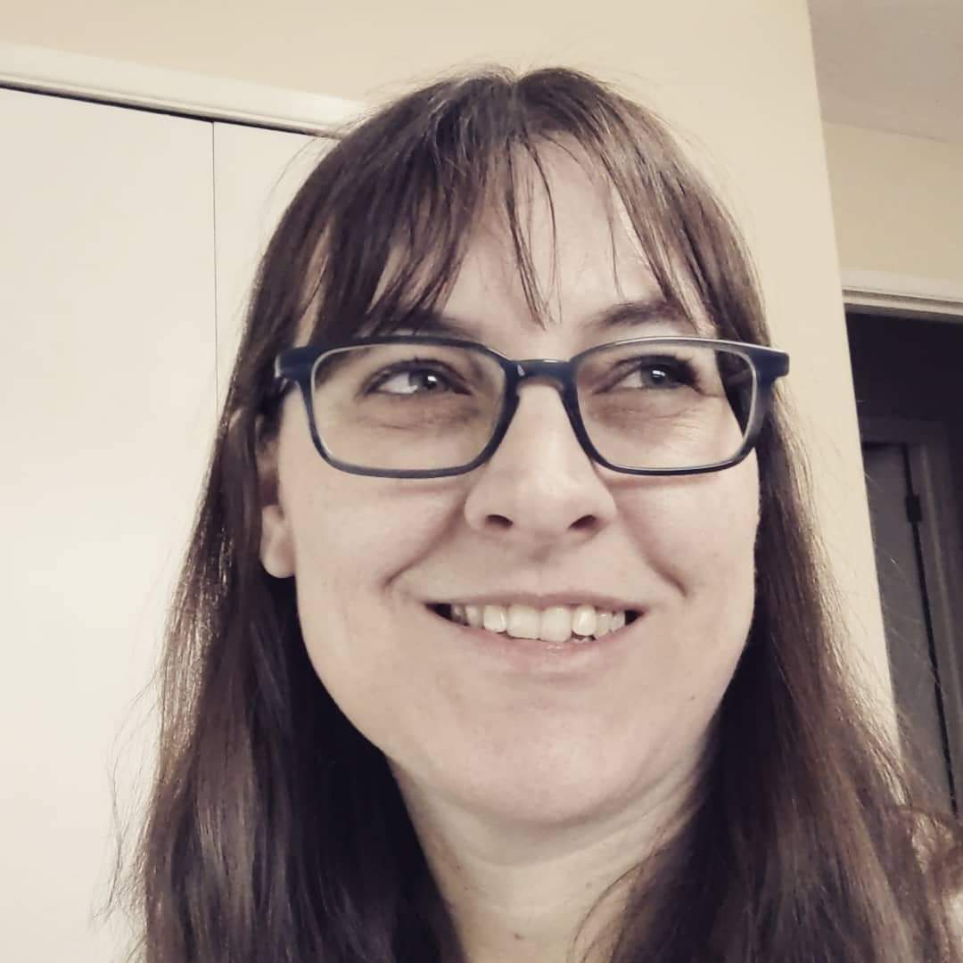A close-up photo of the author, smiling and looking off to the side