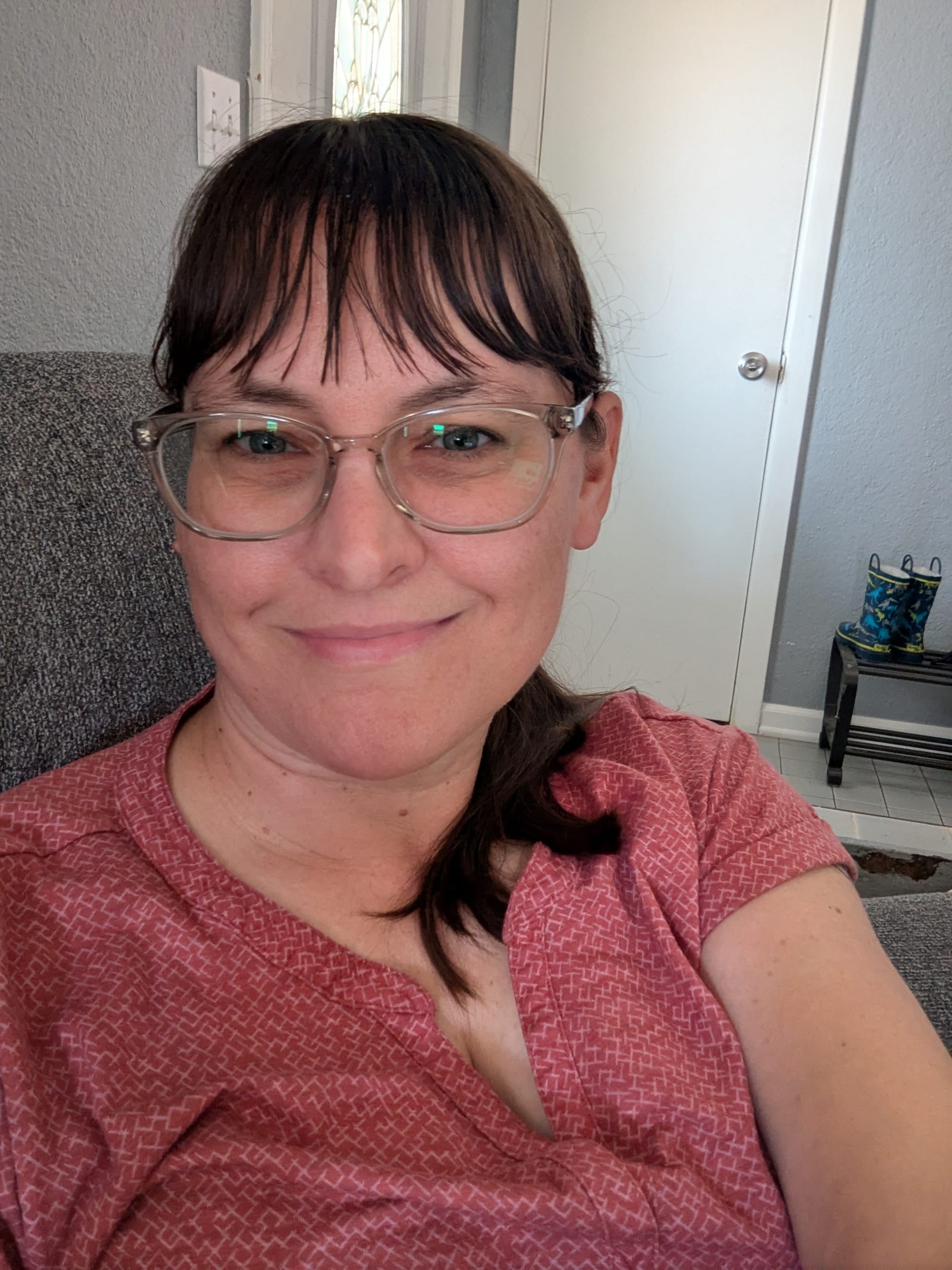 Close-up self-portrait of me sitting in a chair, sporting new glasses