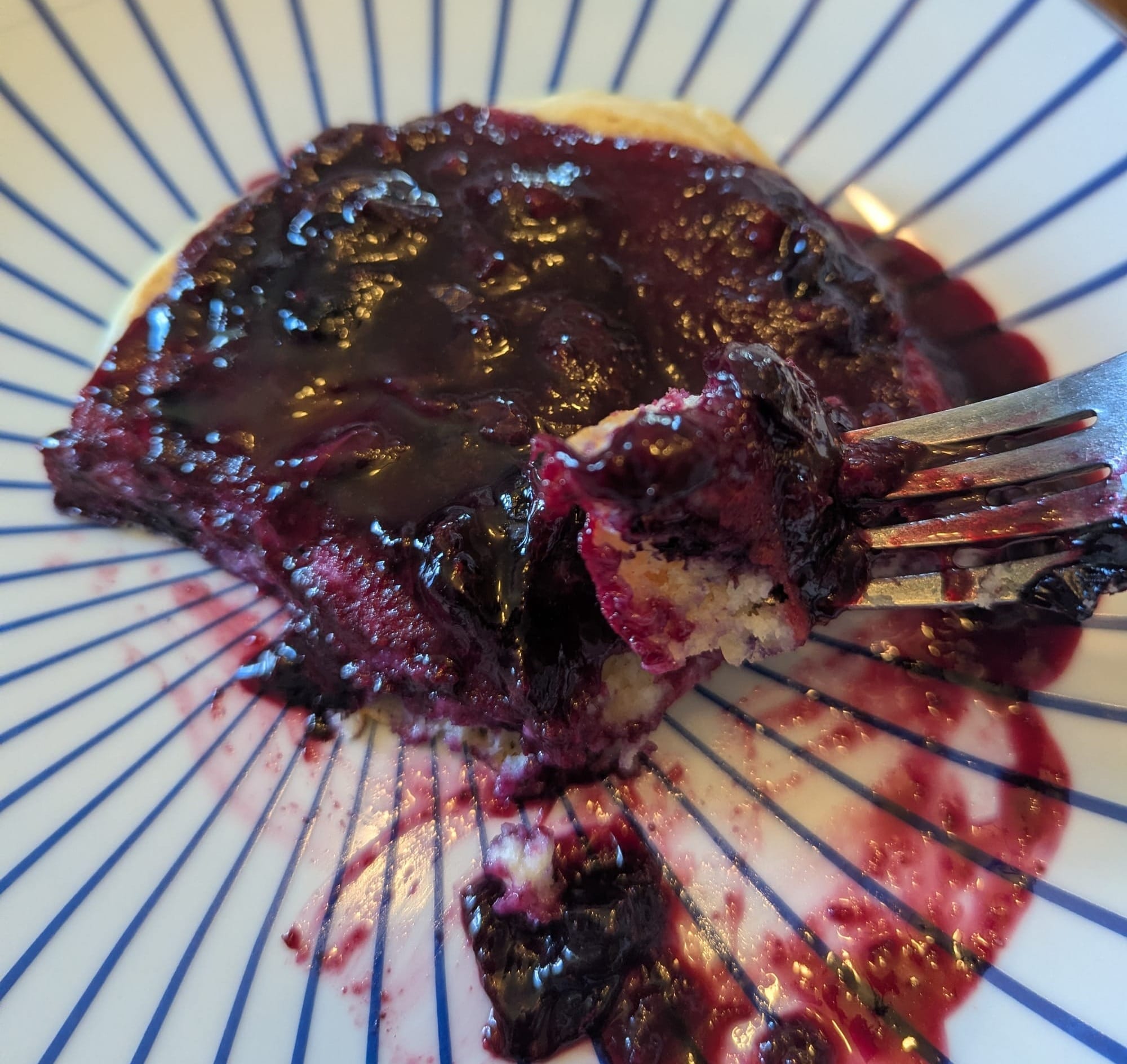 A pancake on a plate smothered with blueberry compote