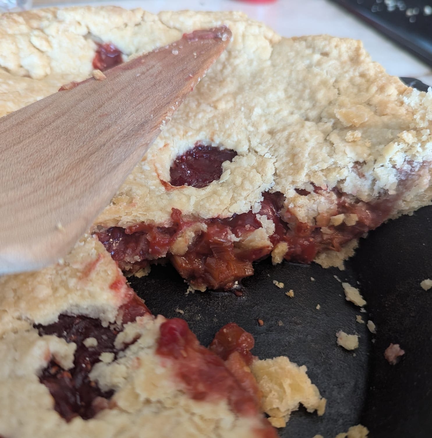 close-up photo of strawberry-rhubarb pie, with a slice removed so you can see the pink, juicy filling