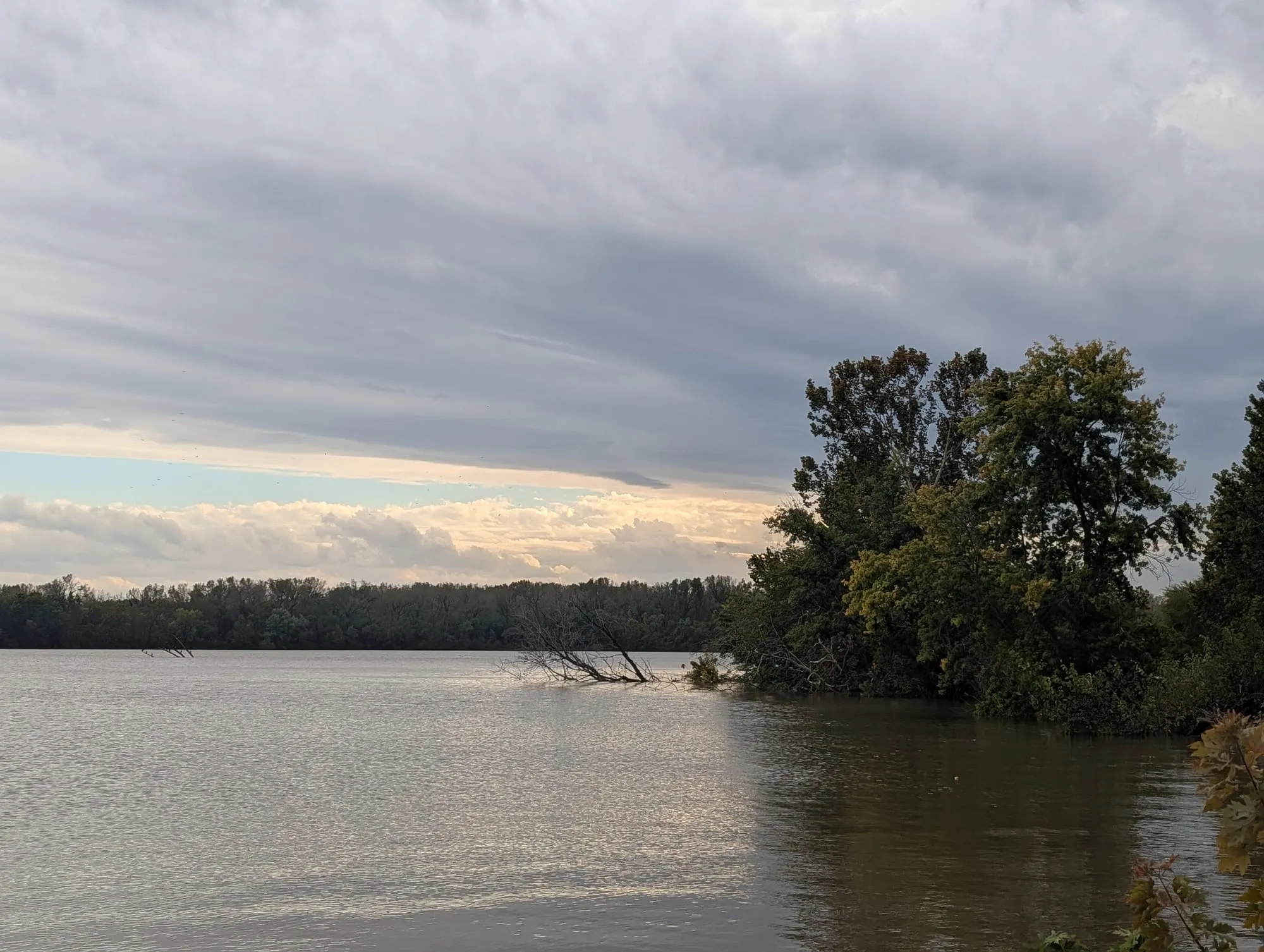 A rippling lake sits beneath a sky that is mostly gray with low-hanging storm clouds