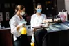 Deux employées offrent des échantillons de gâteaux dans un centre commercial de Berlin, en Allemagne, le 9 mai 2020. (Xinhua/