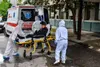 Le personnel médical portant des combinaisons de protection transporte un patient infecté par le COVID-19 à Skopje, en Macédo