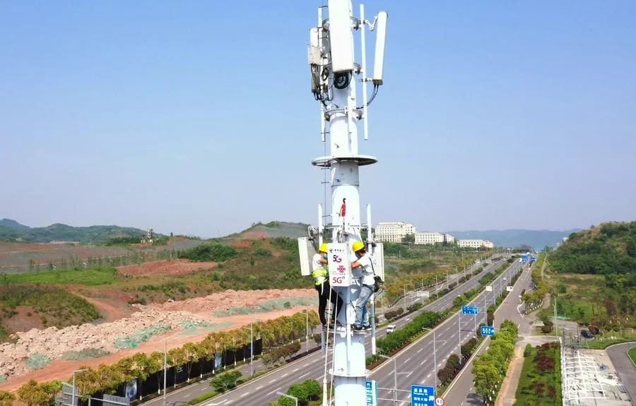 Photo aérienne d'employés travaillant sur le chantier d'une station de base 5G dans la Zone de haute technologie de Chongqing