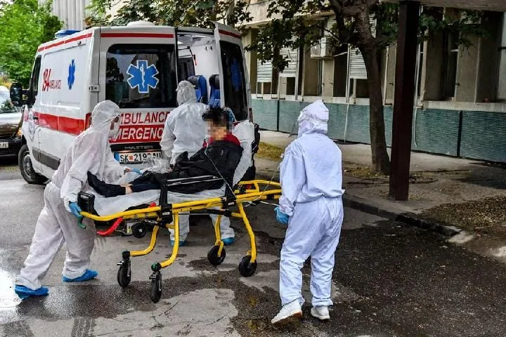 Le personnel médical portant des combinaisons de protection transporte un patient infecté par le COVID-19 à Skopje, en Macédo