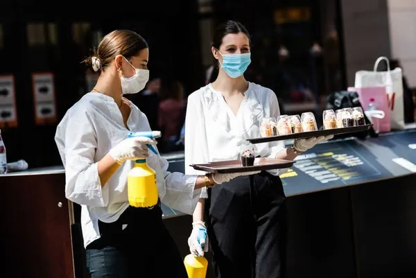 Deux employées offrent des échantillons de gâteaux dans un centre commercial de Berlin, en Allemagne, le 9 mai 2020. (Xinhua/
