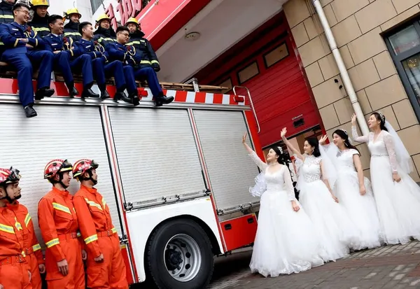 Des pompiers et leurs épouses posent lors de leur cérémonie de mariage de groupe à Shanghai, dans l'est de la Chine, le 4 jan