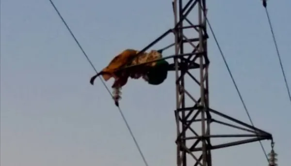 Une femme en état de démence escalade un pylône électrique